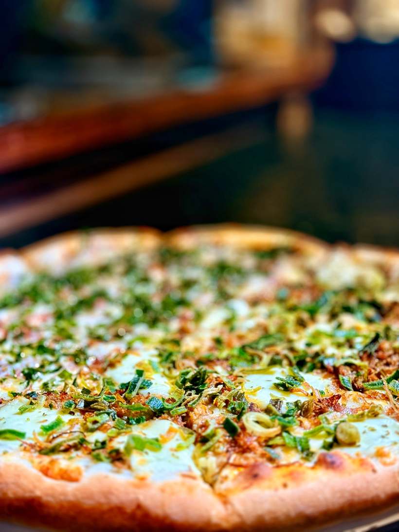 Pizza coberta com cebolinha e alho-poró picado